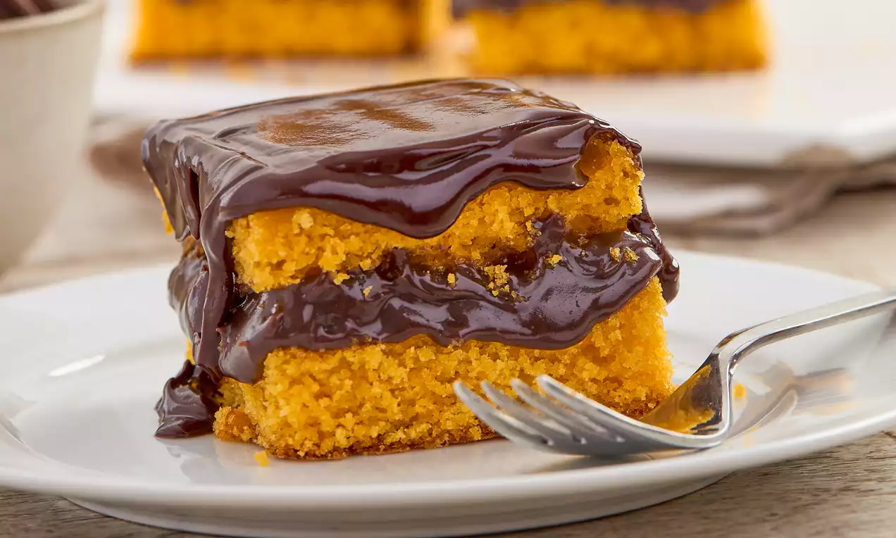 Foto de um bolo de cenoura com cobertura de chocolate.